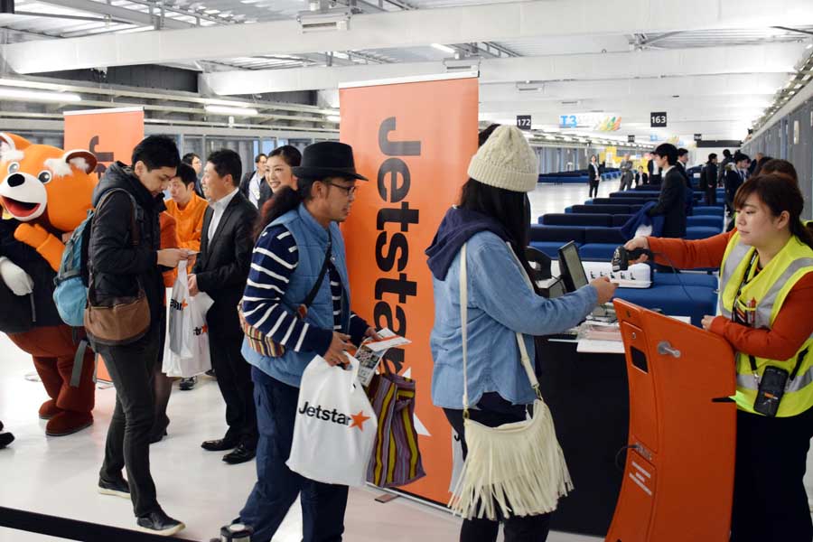 成田空港にオープンした「第3旅客ターミナル」からの出発第1便、新千歳行きジェットスター・ジャパン101便に搭乗する乗客＝2015年4月8日午前、同ターミナル国内線出発ゲート（画像：時事）