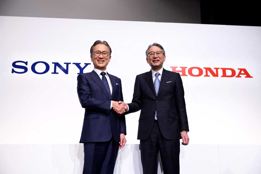 2022年3月4日、東京都内で行われた共同記者会見の最後に、電気自動車の開発・販売を行う新会社を立ち上げると発表し、握手するソニーの吉田憲一郎社長（左）とホンダの三部敏宏社長がポーズをとった（画像：AFP＝時事）