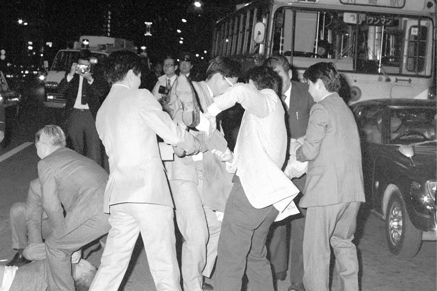 「川崎バス闘争」の現場。「車いすのまま乗車を」と路上に寝転ぶなどしてバスを止めて抗議する身障者らを排除する警官ら。神奈川県川崎市の国鉄川崎駅前。1977年4月12日撮影（画像：時事）