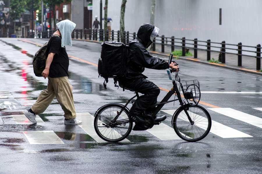 雨の中を走るフードデリバリー（画像：写真AC）