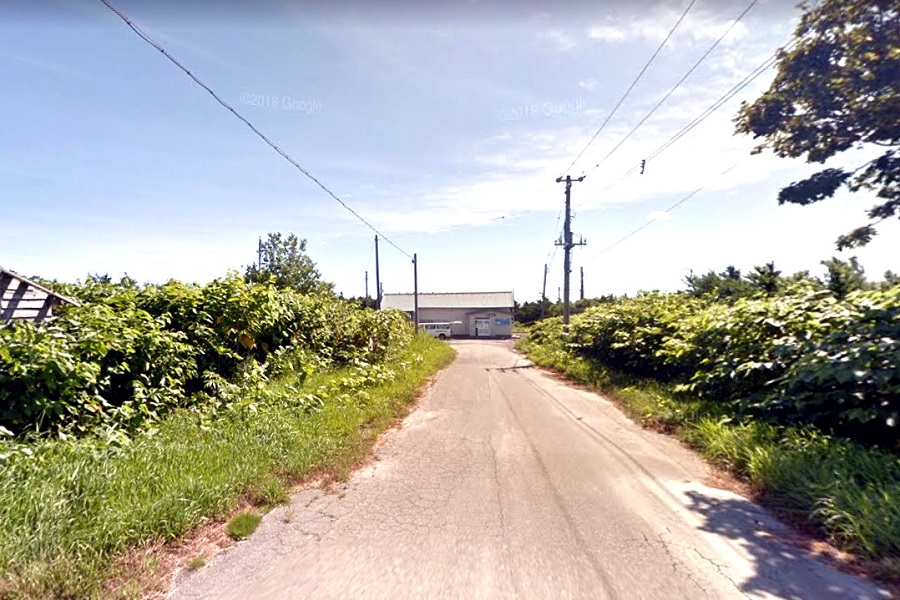 抜海駅に続く公道。奥に見えるのが駅舎（画像：（C）Google）