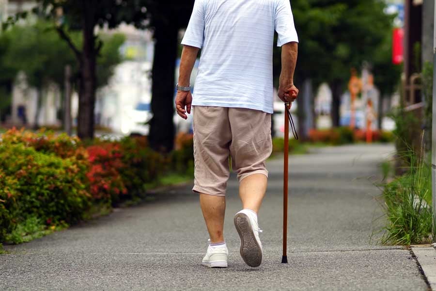 杖を持って歩く高齢者(画像:写真AC)