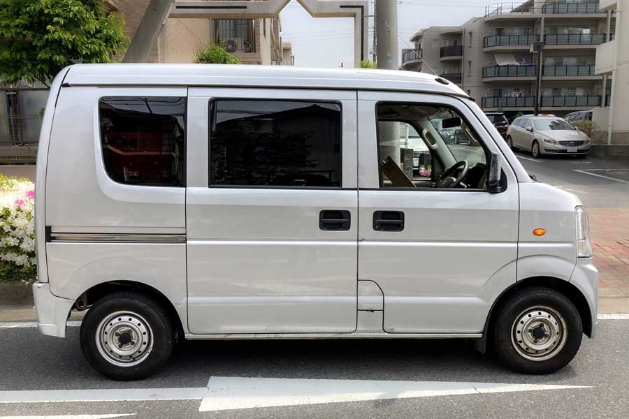 宅配便を住宅街で配送中の軽バンイメージ（画像：写真AC）