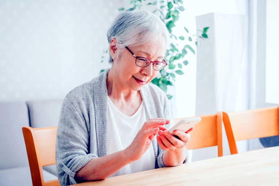 スマートフォンを使う高齢者女性のイメージ（画像：写真AC）