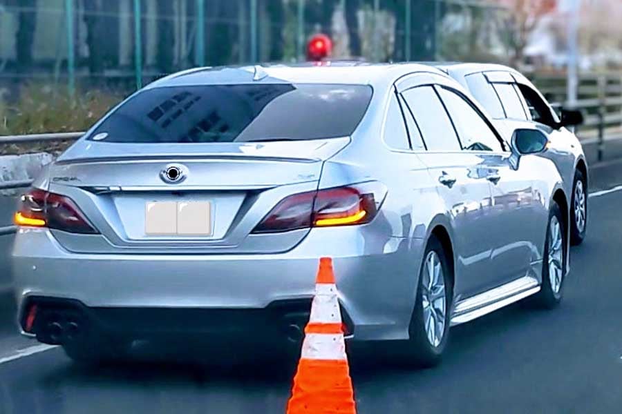 違反車両を停車させる覆面パトカー(画像:写真AC)