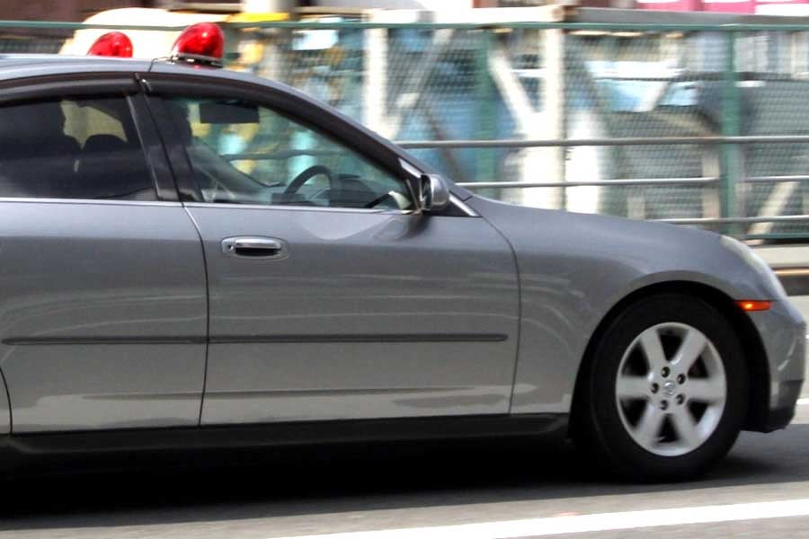 警光灯をつけて緊急走行中の覆面パトカー(画像:写真AC)