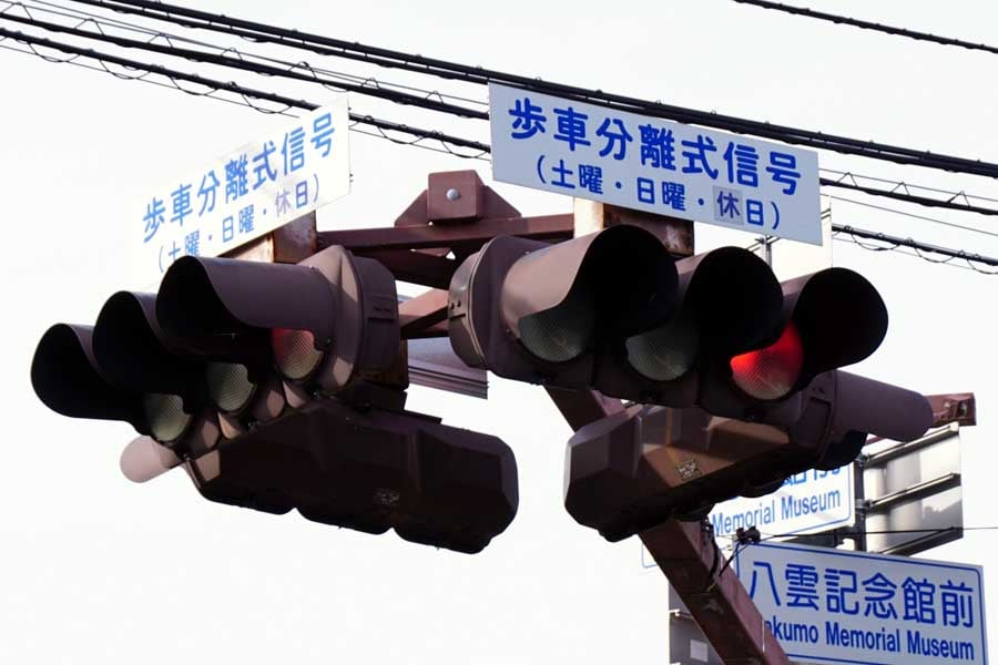 「歩車分離式信号」と書かれた補助板が設置されている信号機(画像:写真AC)