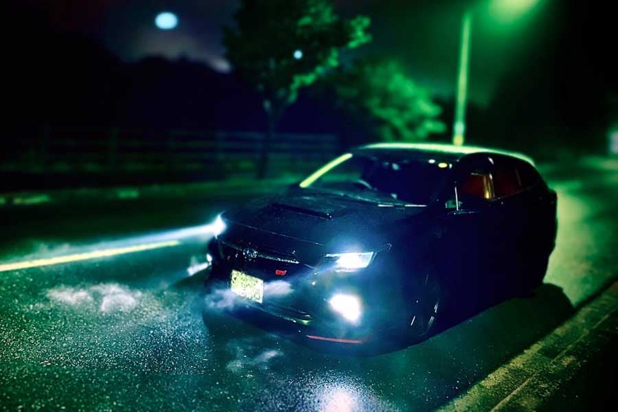 ヘッドライトをつけて夜道を走行する車（画像：写真AC）