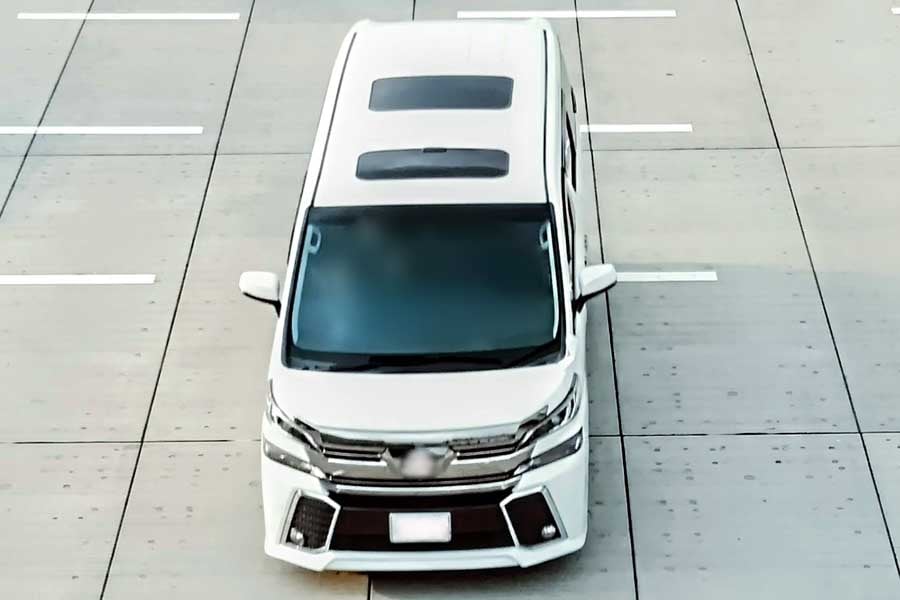交差点を走るサンルーフ付きの普通自動車（画像：写真AC）