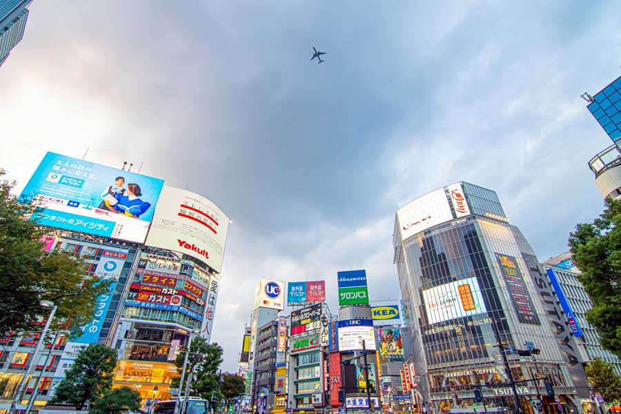渋谷区上空を飛ぶ飛行機（画像：写真AC）