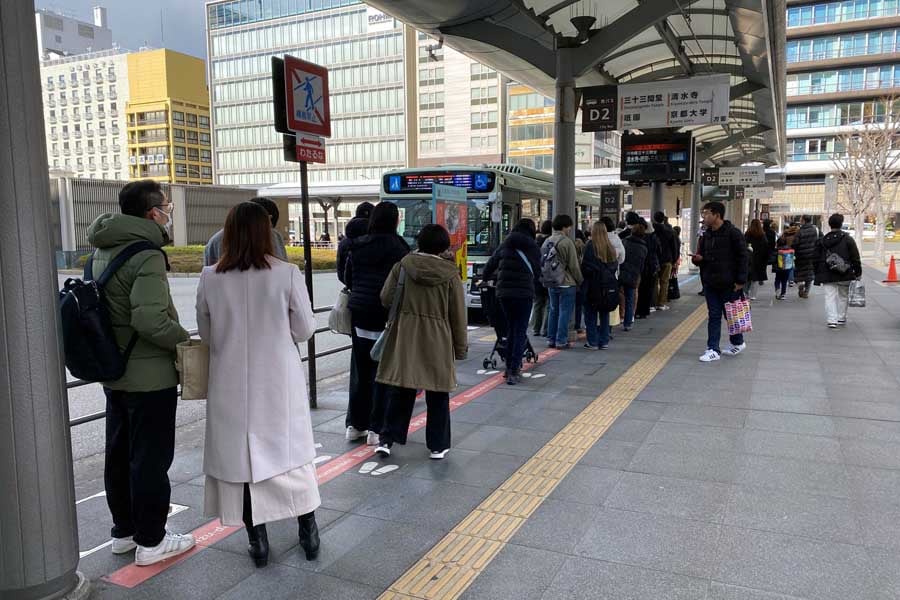 京都駅烏丸口の路線バス乗り場で長い列を作る観光客ら（画像：高田泰）