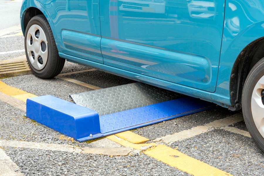 フラップ式コインパーキングに駐車するクルマ（画像：写真AC）