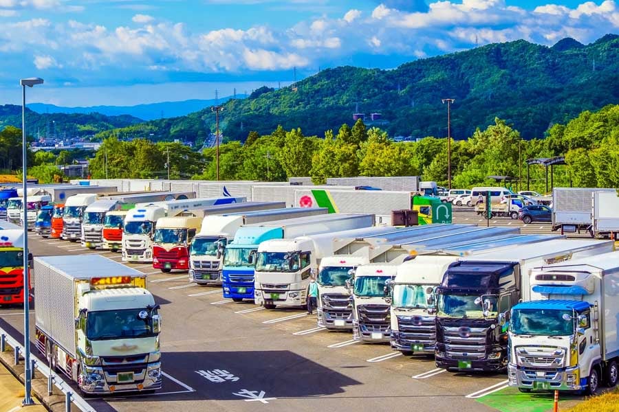 サービスエリアに停車するトラックの風景（画像：写真AC）