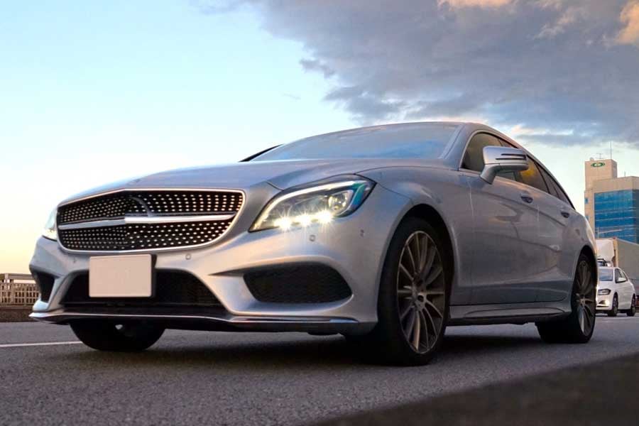 ライトをつけて走行する自動車（画像：写真AC）