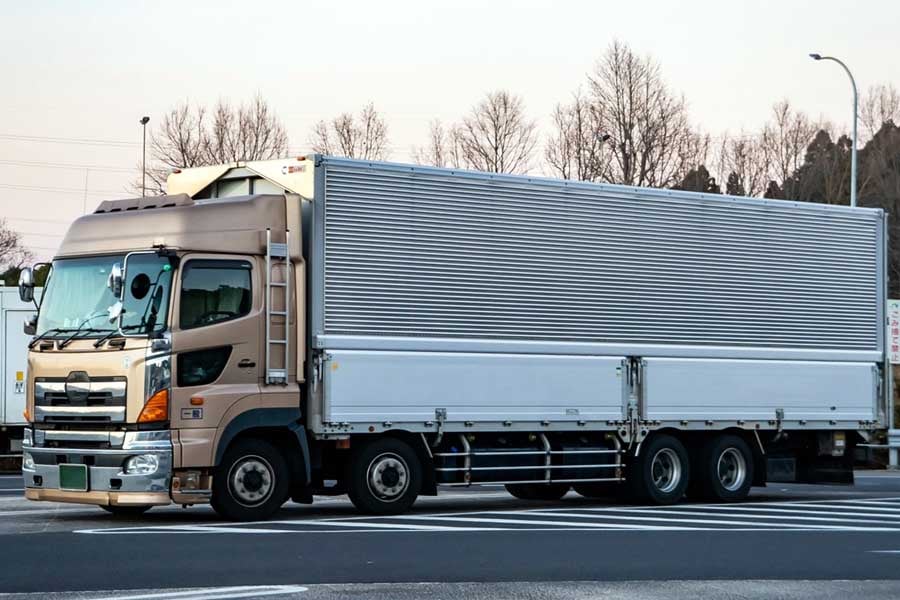 車線幅が狭いと大型車は車線からはみ出さざるを得ない（画像：写真AC）