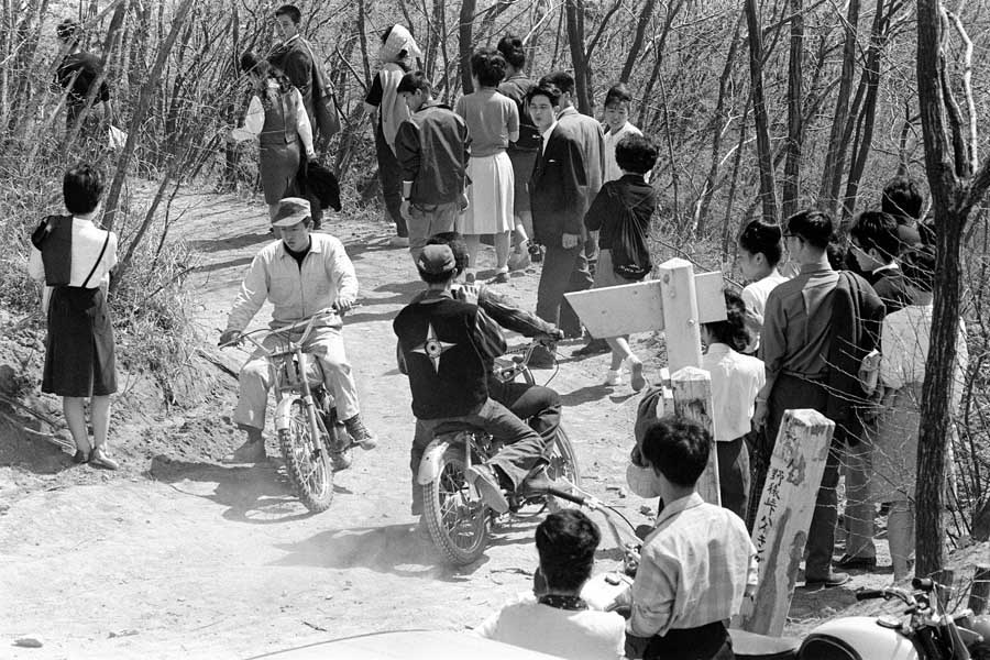 1964年5月撮影。野猿峠ハイキングコースをオートバイに乗ったカミナリ族が突っ走る。ハイカーは道ばたに身を寄せ、しばしぼうぜんと見送る。東京・八王子市（画像：時事）