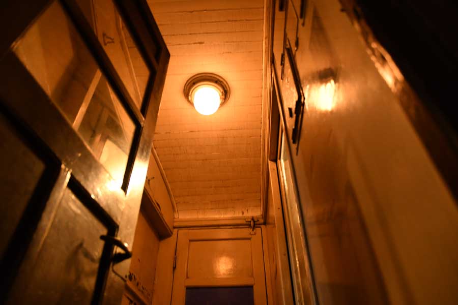 令和の旅人を迎えた夜汽車のデッキ。オレンジ色の照明のやわらかな光があたりをつつむ（画像：広岡祐）