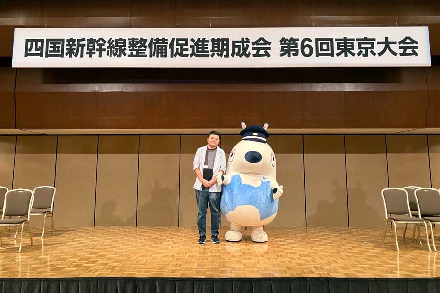 「つなぐん」と記念撮影する筆者(画像:北村幸太郎)