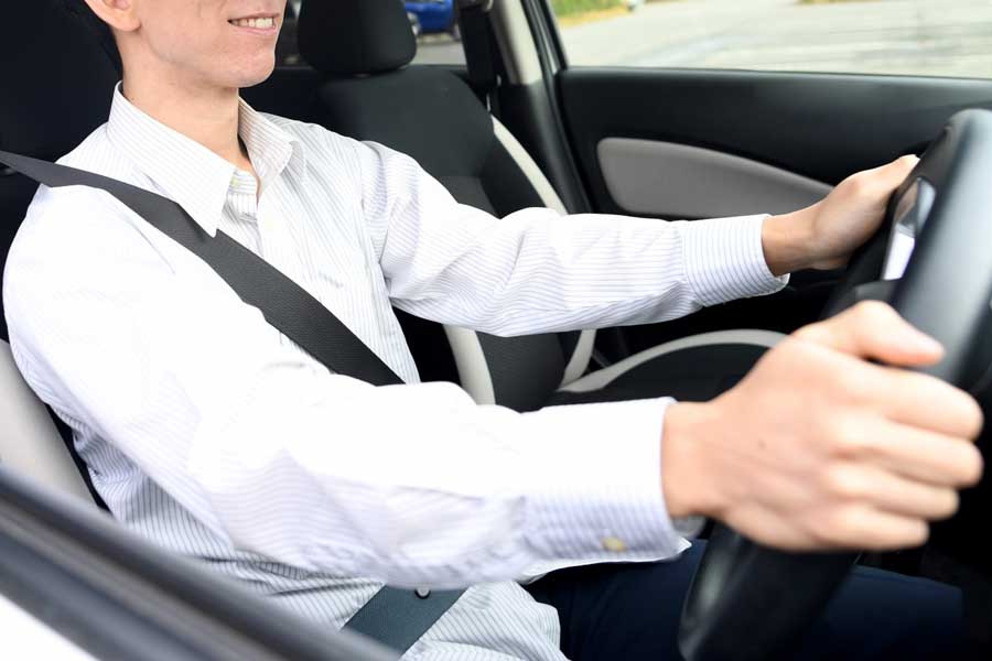 笑顔で運転をする男性（画像：写真AC）