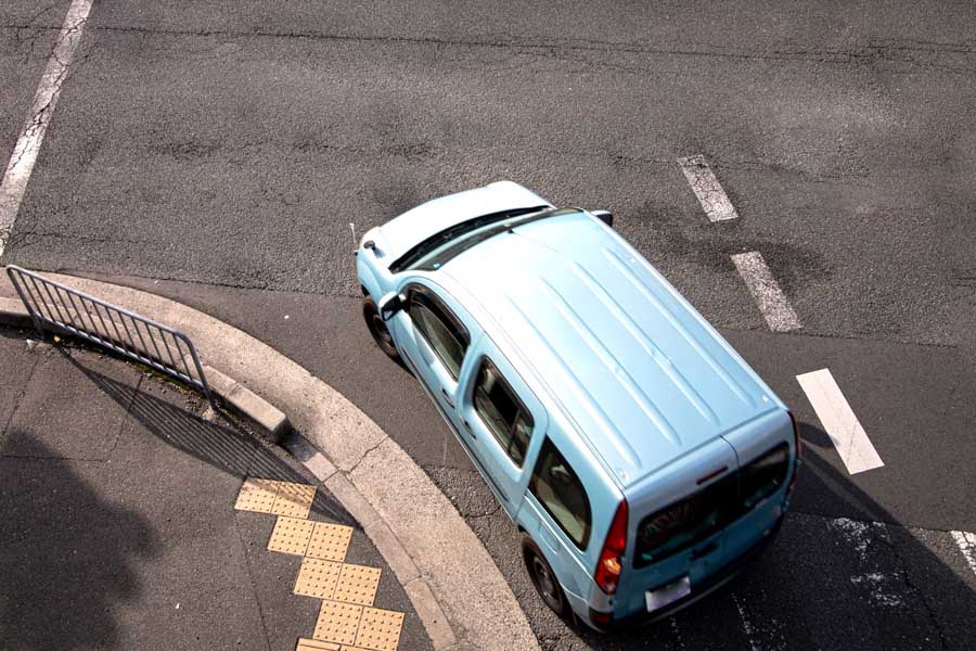 左側端に沿って左折する車両(画像:写真AC)