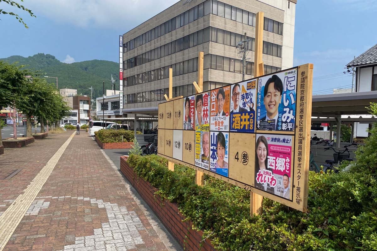 参院選京都選挙区立候補者のポスターが掲示されたJR西舞鶴駅前の掲示板（画像：高田泰）