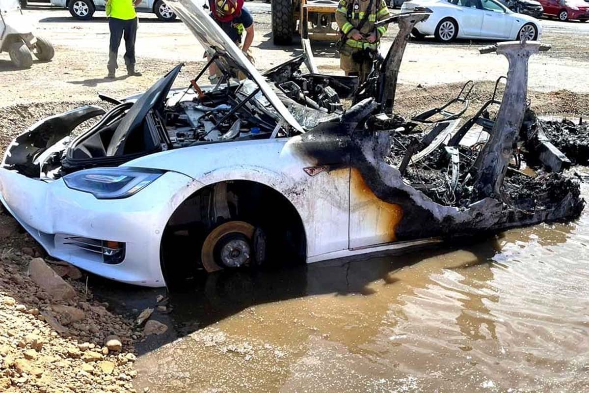 燃えたテスラ・モデルS。カリフォルニア州の消防士はテスラのバッテリーコンパートメントの頑固な炎を消すために水を満たしたピットを使用した。電気自動車の炎と戦う際の特有のハードルを典型的に示している。2022年6月9日撮影（画像：AFP＝時事）