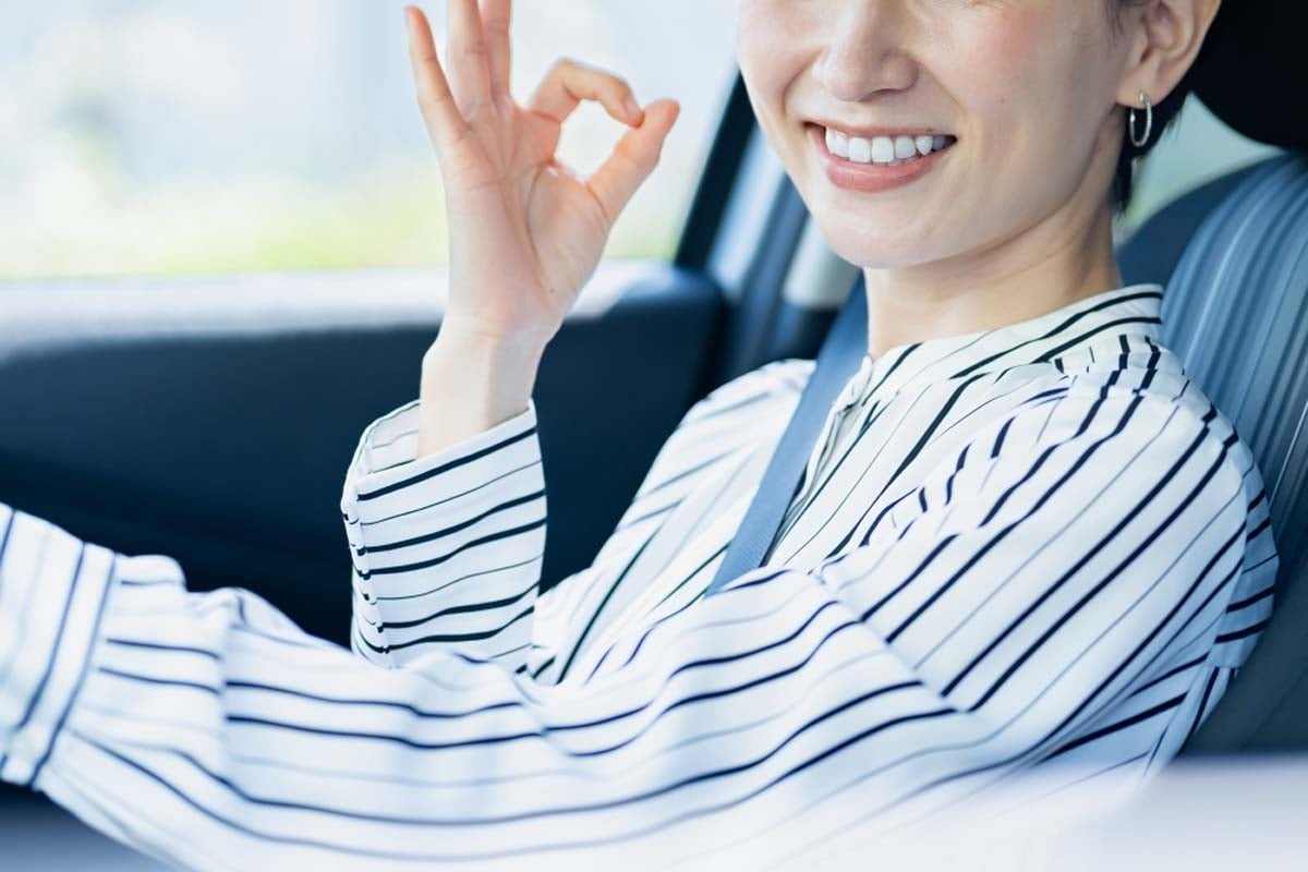 笑顔でクルマに乗る女性(画像:写真AC)