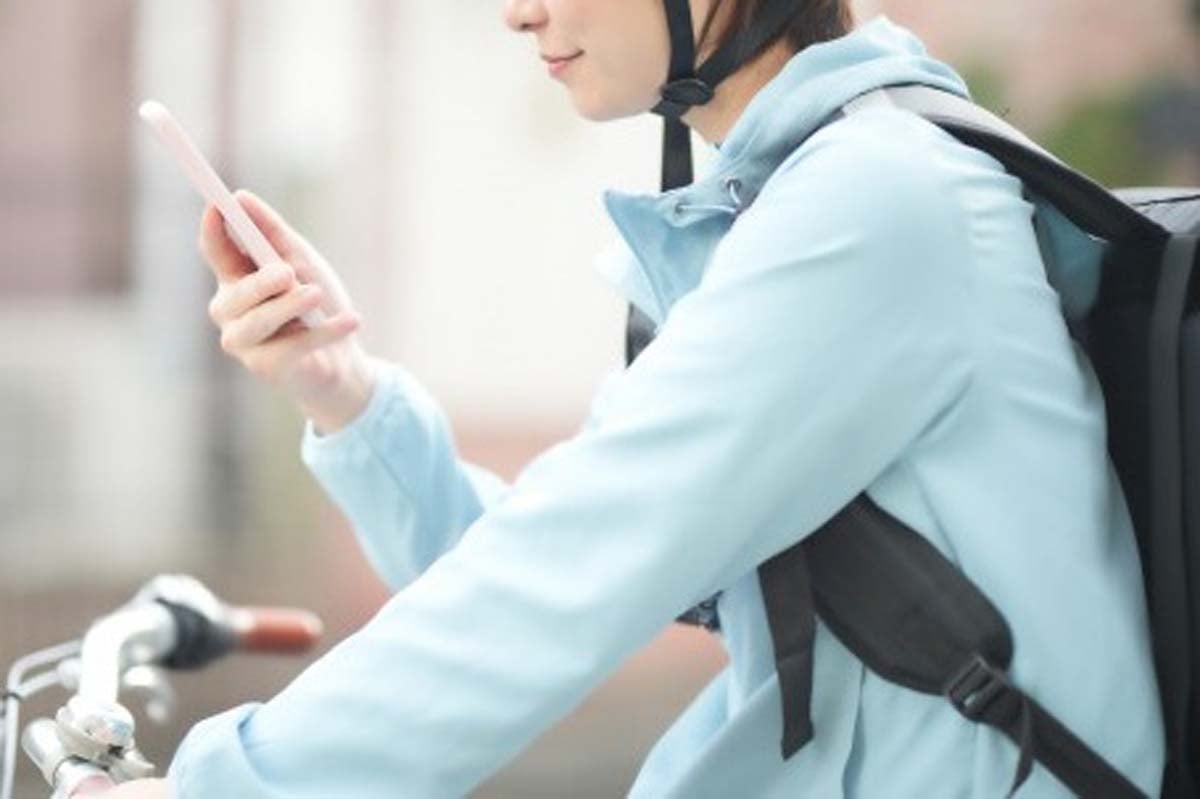 スマホで確認をする配達員（画像：写真AC）