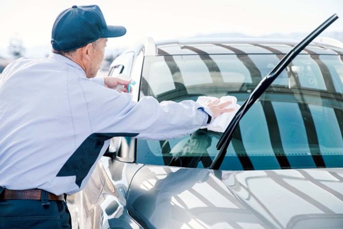 洗車をするレンタカー会社の社員イメージ（画像：写真AC）