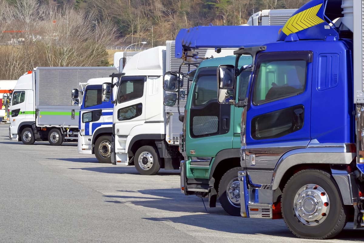 パーキングエリアに並ぶ大型トラックの車列（画像：写真AC）